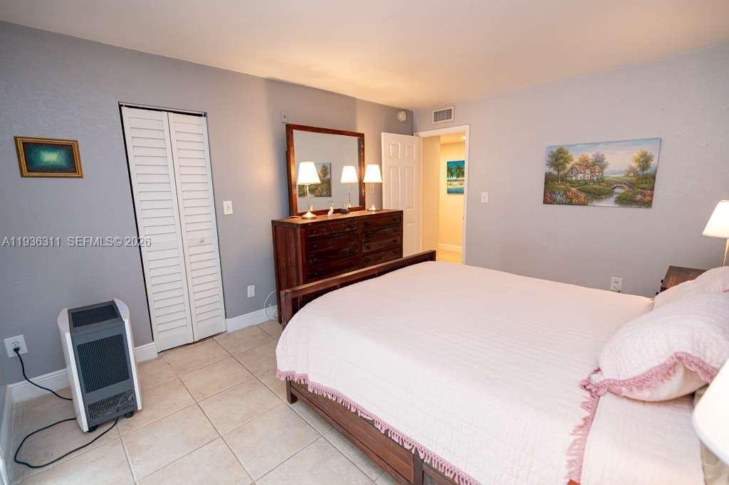 8600 Southwest 109th Avenue, Unit 4114 Miami, FL 33173 - Photo 12 of 44 a bedroom with a bed and a mirror
