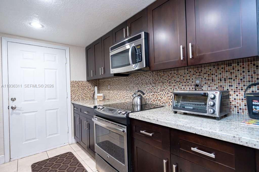 8600 Southwest 109th Avenue, Unit 4114 Miami, FL 33173 - Photo 26 of 44 a kitchen with stainless steel appliances granite countertop a sink stove and microwave