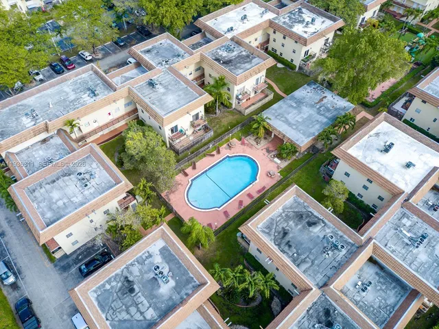 an aerial view of a residential houses with outdoor space and street view