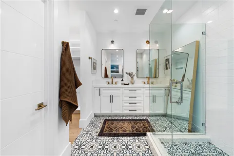 a bathroom with a sink a toilet a mirror and shower