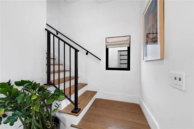 a view of a hallway with wooden floor and stairs