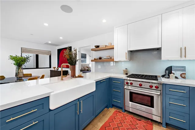 a kitchen with stainless steel appliances white cabinets and a stove top oven