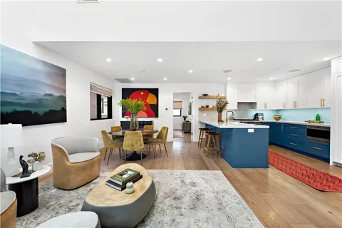 a living room with furniture kitchen view and a flat screen tv