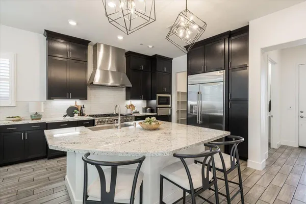 a kitchen with stainless steel appliances granite countertop a sink refrigerator and cabinets