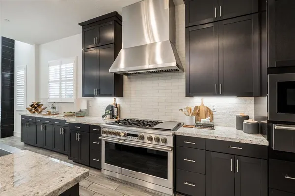 a kitchen with kitchen island granite countertop a sink stove and refrigerator