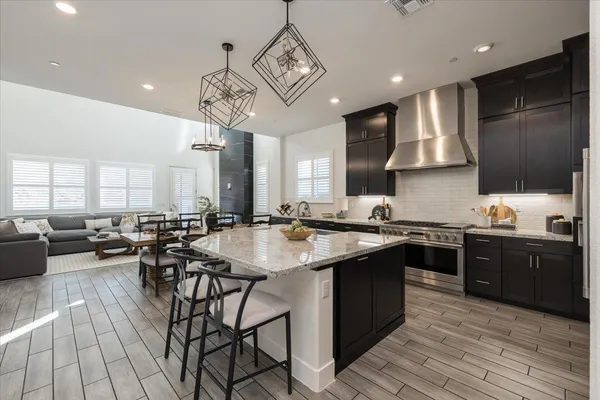 a kitchen with stainless steel appliances granite countertop wooden cabinets a dining table and chairs