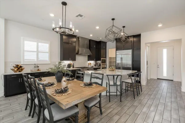 a dining room filled chandelier and wooden floor