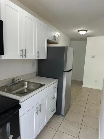 a kitchen with a sink and a refrigerator