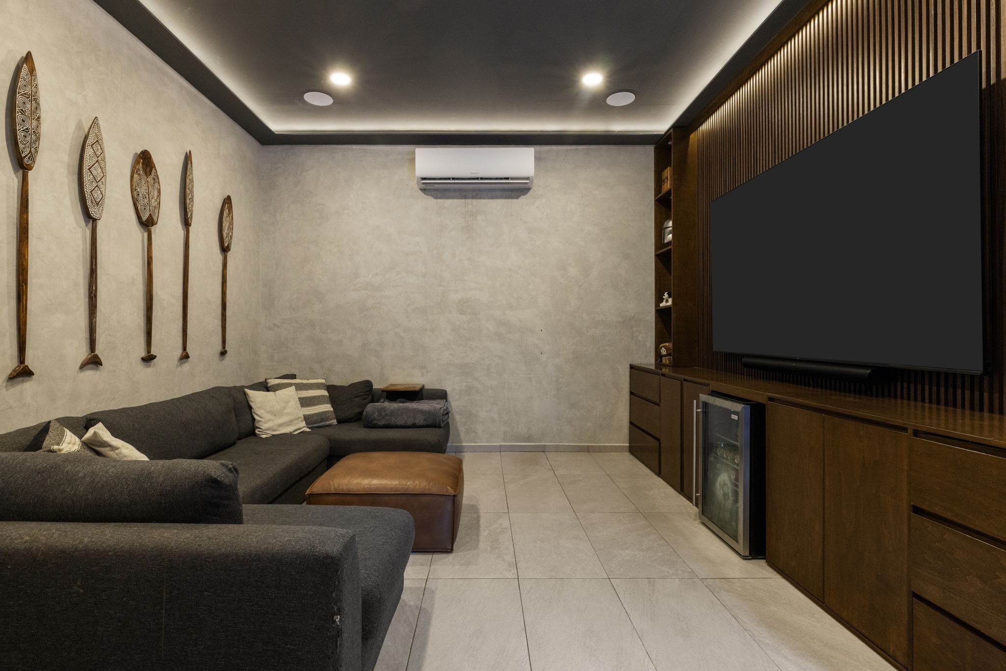 6 Country Club, Unit 4 Nome, TX 77629 - Photo 16 of 45 This versatile flex room is beautifully executed as a state-of-the-art media room, offering a secluded and cozy retreat for movie nights or private relaxation. Featuring a stunning, floor-to-ceiling vertical wood-slat accent wall, and custom-integrated hardwood millwork providing clean storage solutions and a dedicated beverage refrigeration niche.