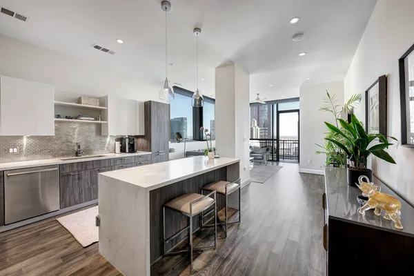 a large kitchen with sink a refrigerator and wooden floor