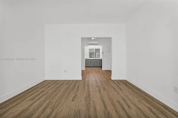 a view of a room with wooden floor and a window