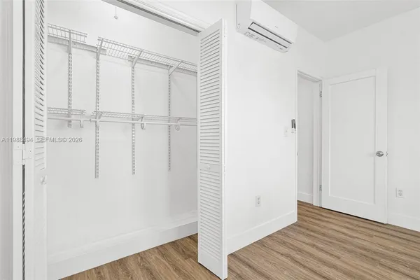 a view of closet area with wooden floor