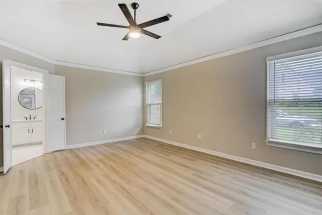 a view of empty room with wooden floor and window