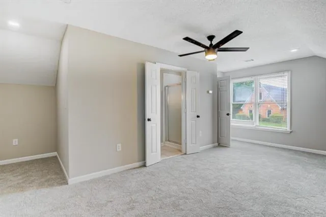 an empty room with a window and a ceiling fan