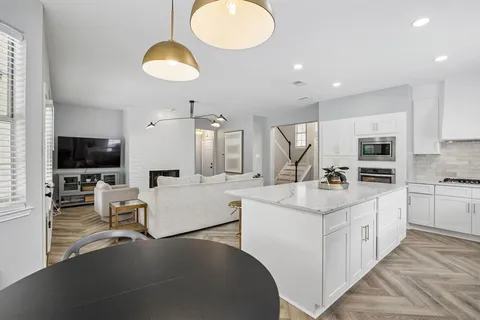a large kitchen with kitchen island a large island a sink stainless steel appliances and cabinets