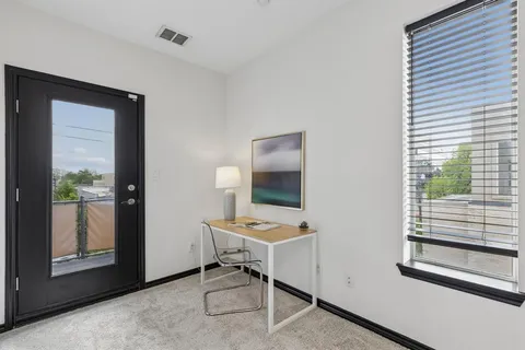 a view of a workspace with furniture and a window