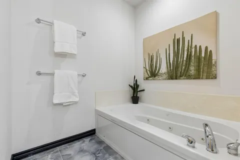 a bathroom with a tub a sink and mirror