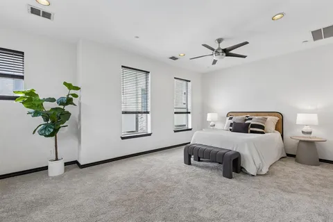 a spacious bedroom with a bed and a potted plant