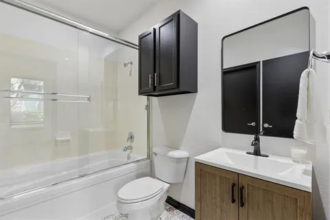 a bathroom with a granite countertop sink toilet and shower