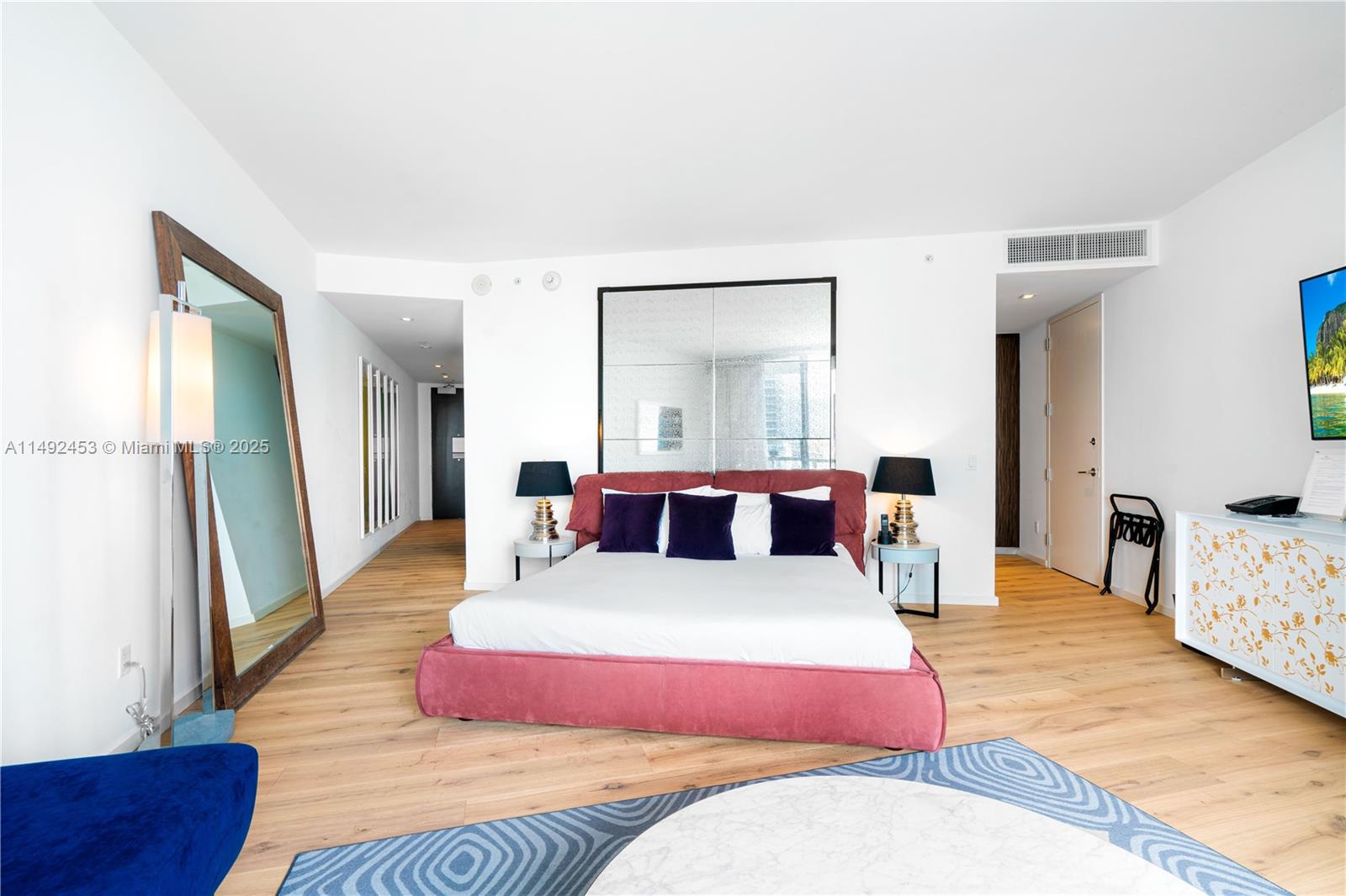 2201 Collins Avenue, Unit 1226 Miami Beach, FL 33139 - Photo 12 of 20 a bedroom with a bed a mirror and lamp