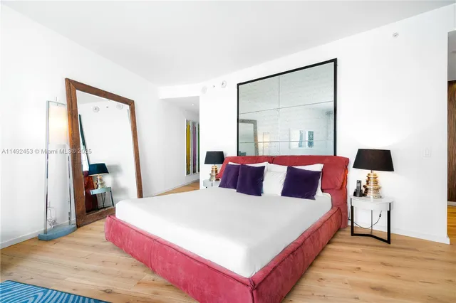 a bedroom with a bed and a large mirror