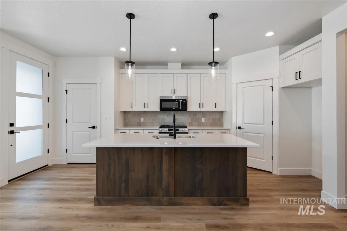 768 South Calhoun Lane Star, ID 83669 - Photo 12 of 36 Central island with a wood-finish base and light-toned countertop, complemented by two pendant lights
