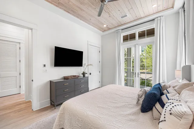 a bedroom with a bed and a flat tv screen on dresser