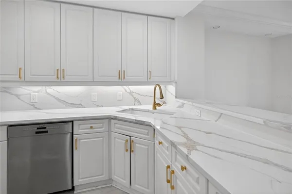 a kitchen with stainless steel appliances granite countertop a sink and white cabinets