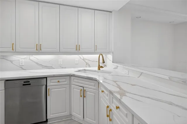 a kitchen with stainless steel appliances granite countertop a sink and white cabinets