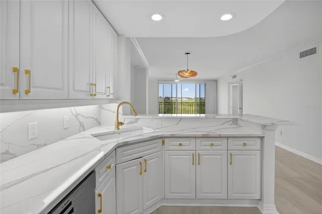 a kitchen with granite countertop white cabinets stainless steel appliances and sink