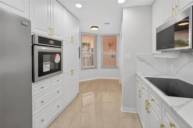 a kitchen with stainless steel appliances granite countertop a sink and a microwave