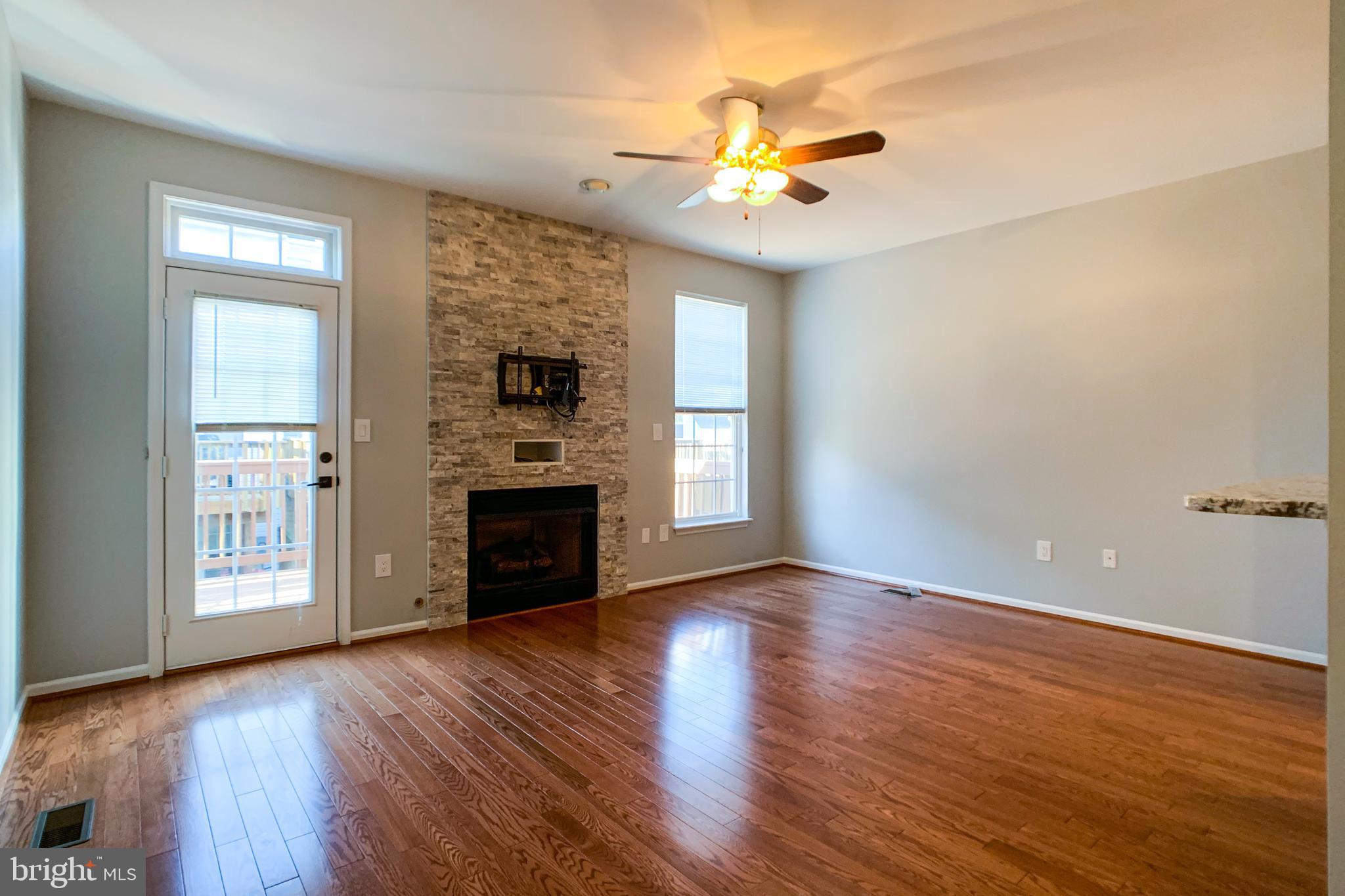 6988 Cromarty Drive Alexandria, VA 22315 - Photo 2 of 62 an empty room with wooden floor a fireplace and windows