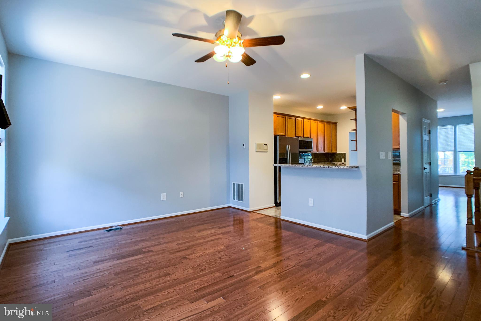 6988 Cromarty Drive Alexandria, VA 22315 - Photo 22 of 62 a view of an empty room and kitchen with wooden floor