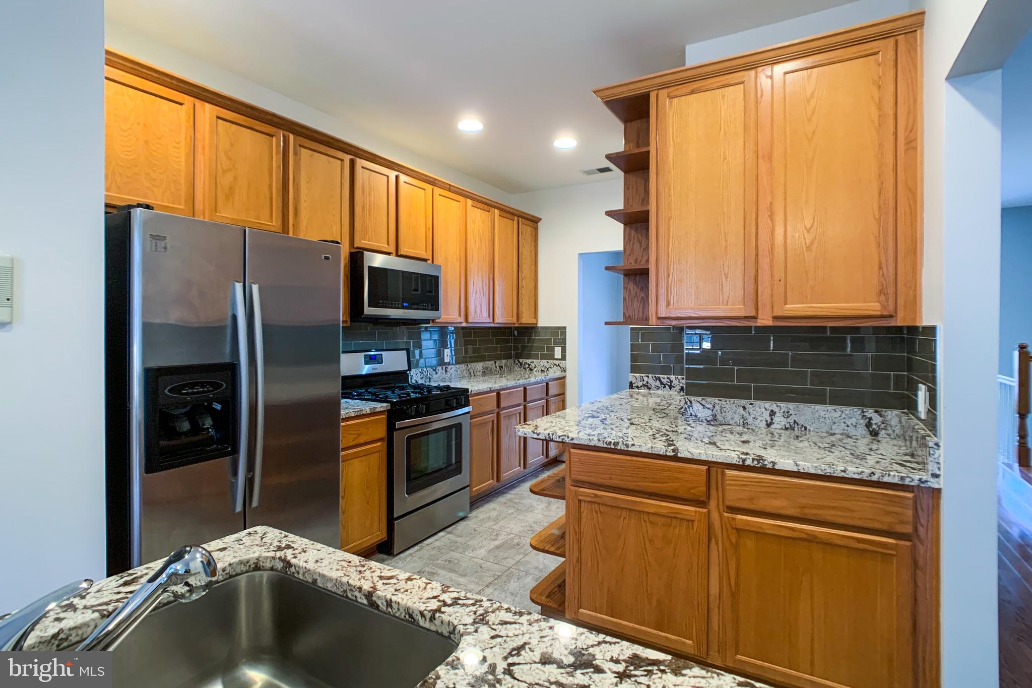 6988 Cromarty Drive Alexandria, VA 22315 - Photo 25 of 62 a kitchen with stainless steel appliances granite countertop a sink stove and refrigerator