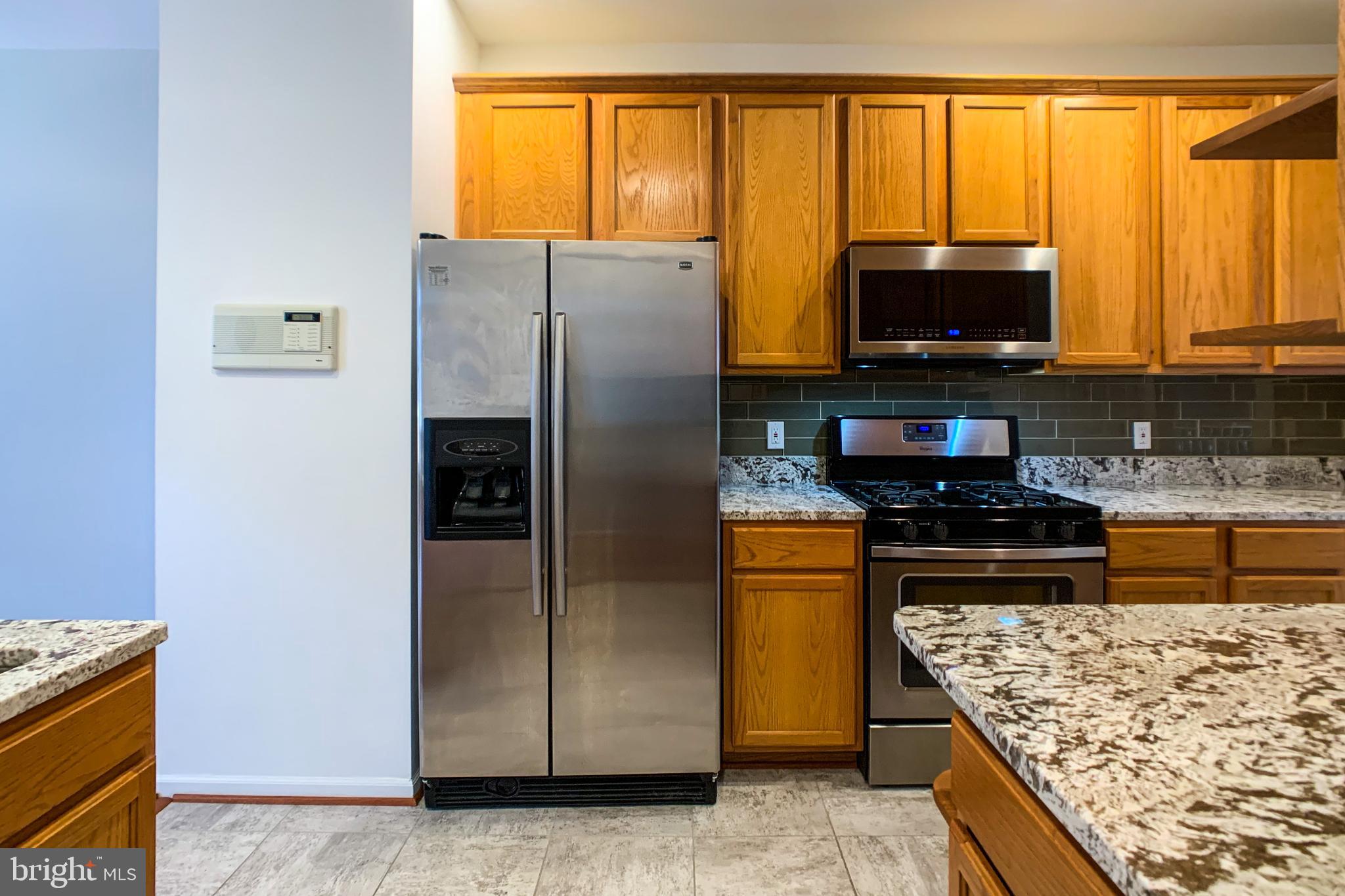 6988 Cromarty Drive Alexandria, VA 22315 - Photo 26 of 62 a kitchen with stainless steel appliances granite countertop a refrigerator stove and microwave