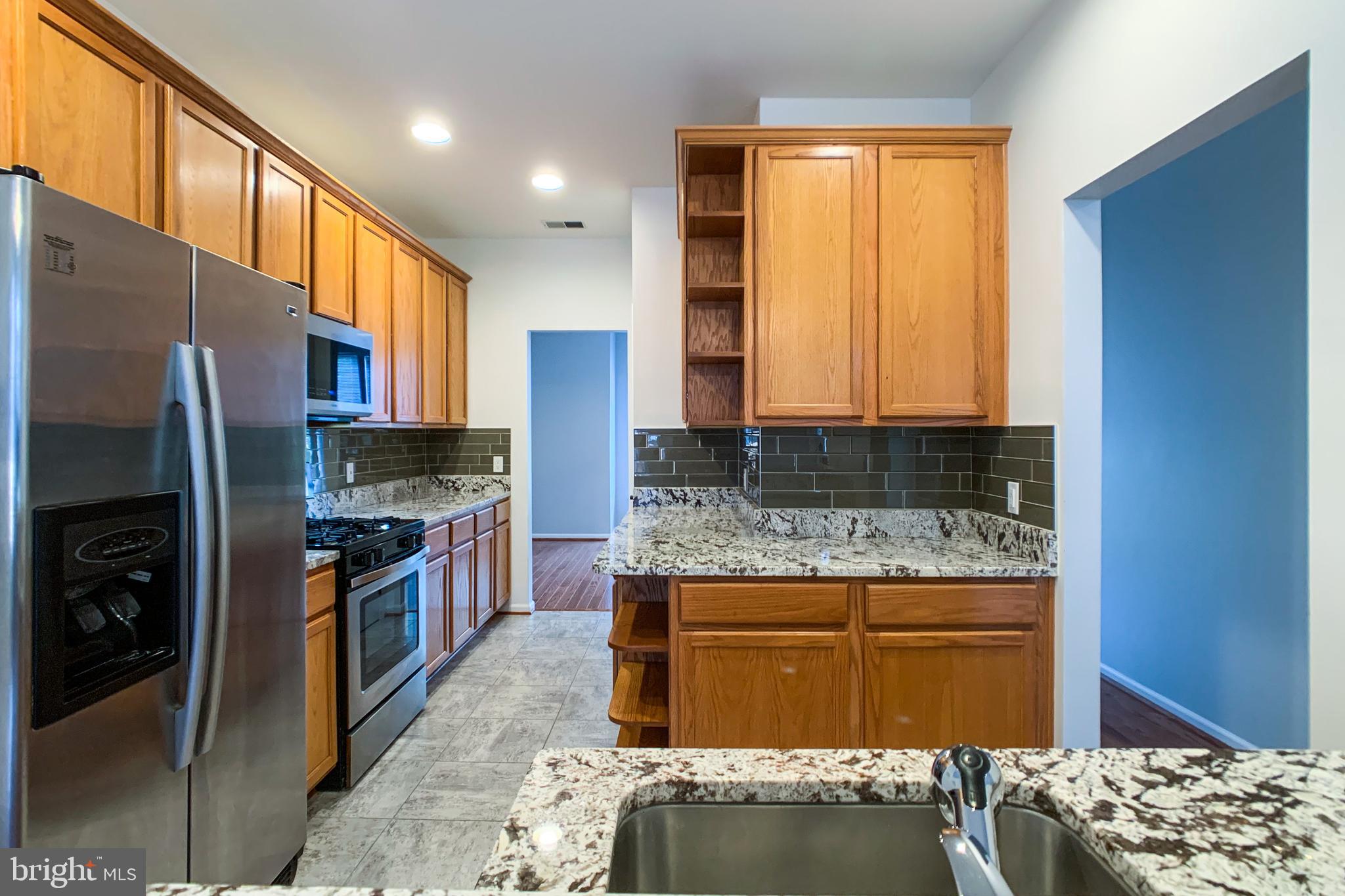 6988 Cromarty Drive Alexandria, VA 22315 - Photo 3 of 62 a kitchen with stainless steel appliances granite countertop a stove a refrigerator and a cabinets