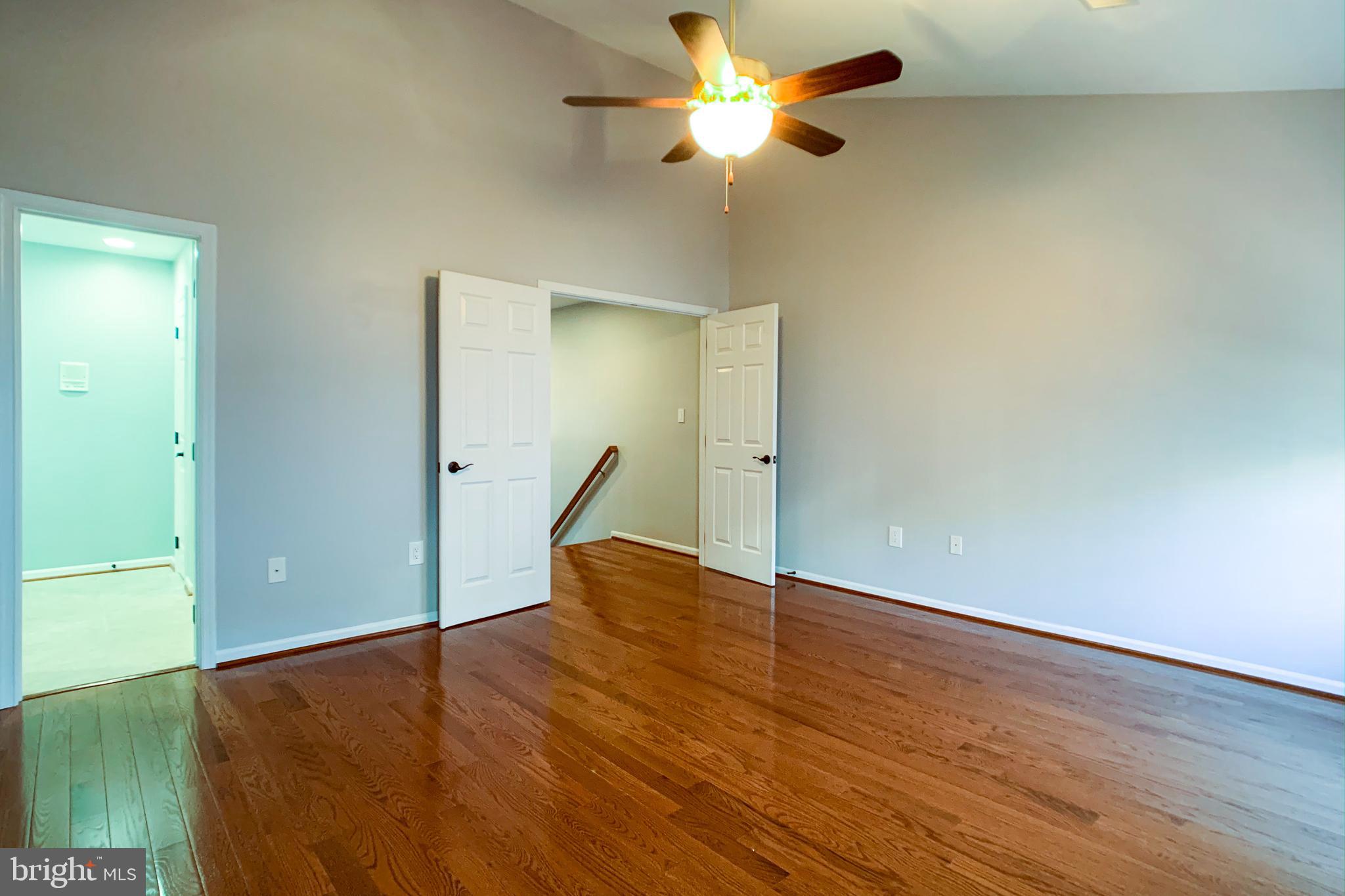 6988 Cromarty Drive Alexandria, VA 22315 - Photo 40 of 62 an empty room with wooden floor and a ceiling fan