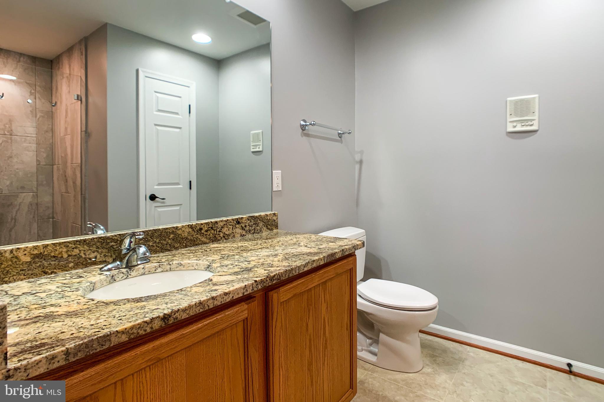 6988 Cromarty Drive Alexandria, VA 22315 - Photo 41 of 62 a bathroom with a granite countertop sink toilet and shower