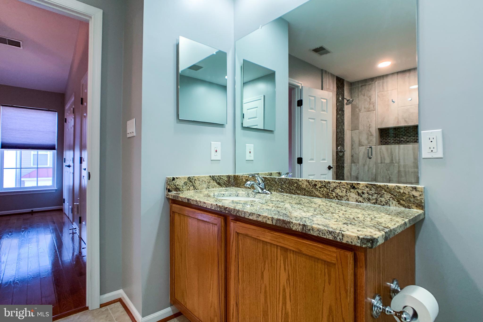 6988 Cromarty Drive Alexandria, VA 22315 - Photo 44 of 62 a bathroom with a granite countertop sink and a mirror
