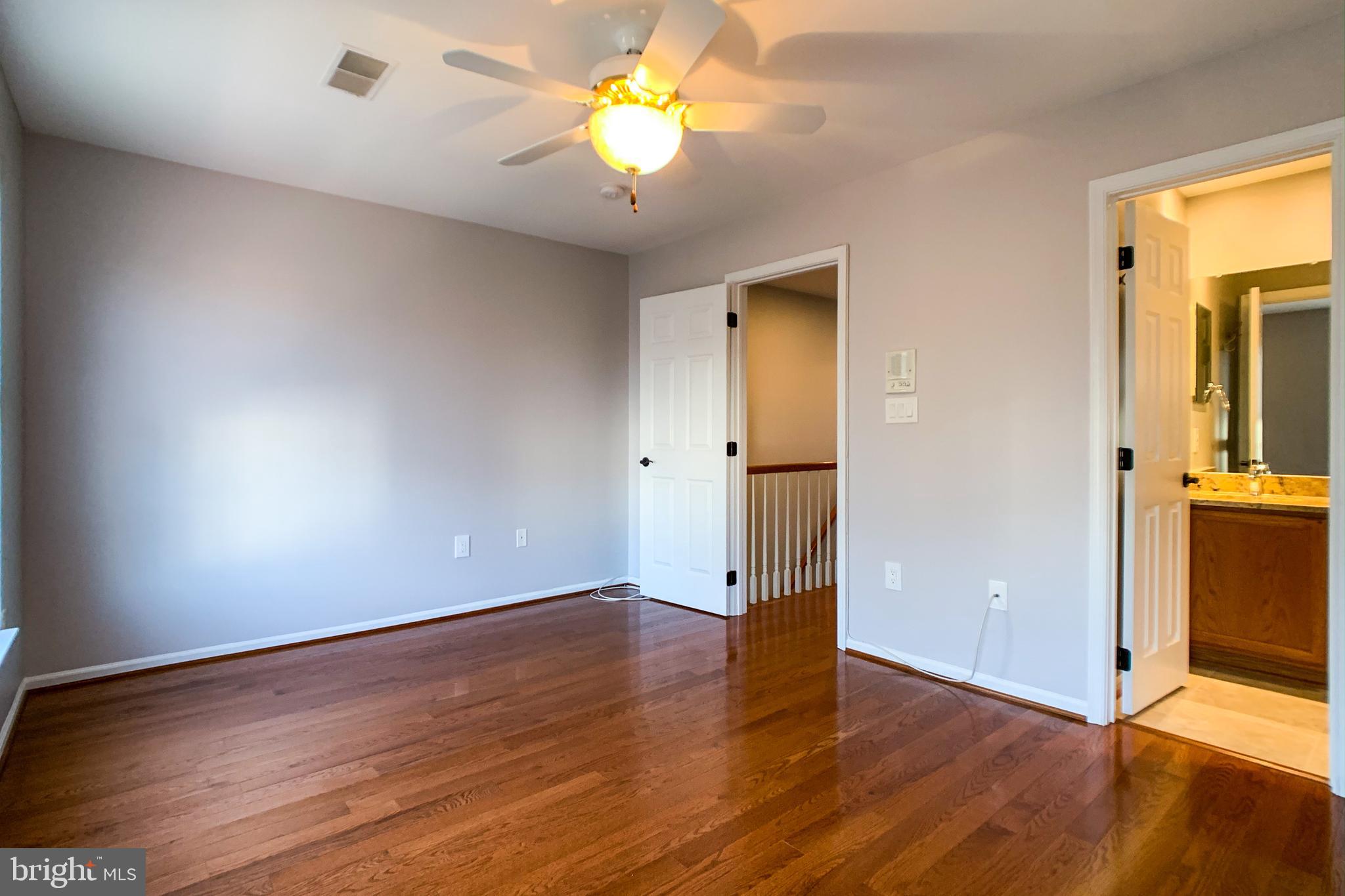 6988 Cromarty Drive Alexandria, VA 22315 - Photo 48 of 62 an empty room with wooden floor and a ceiling fan