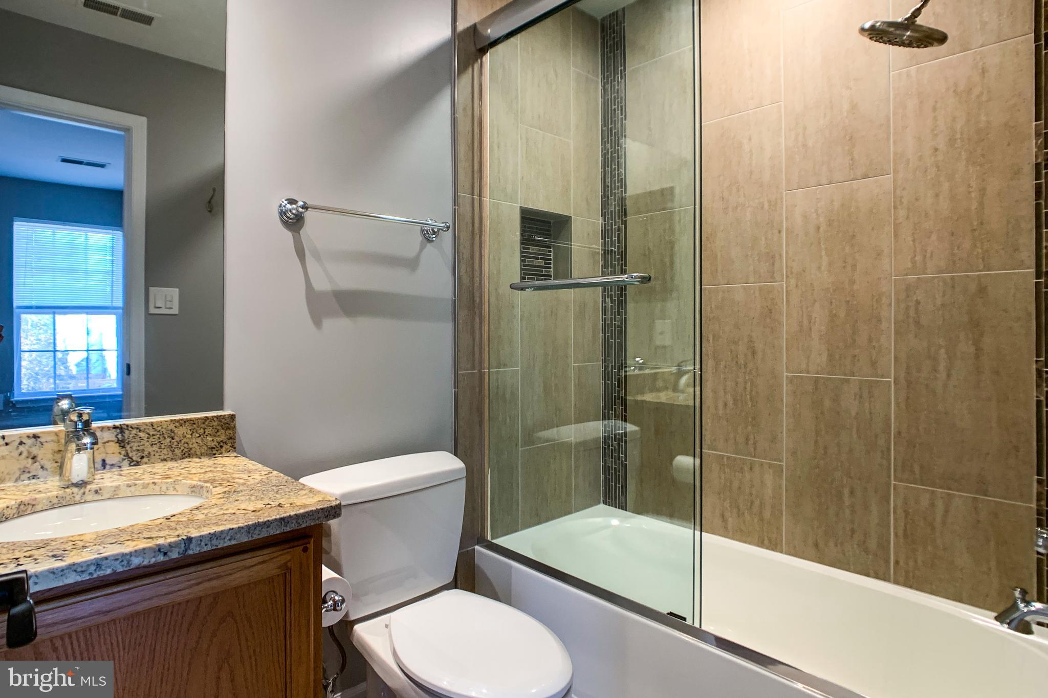 6988 Cromarty Drive Alexandria, VA 22315 - Photo 49 of 62 a bathroom with a granite countertop sink toilet and shower