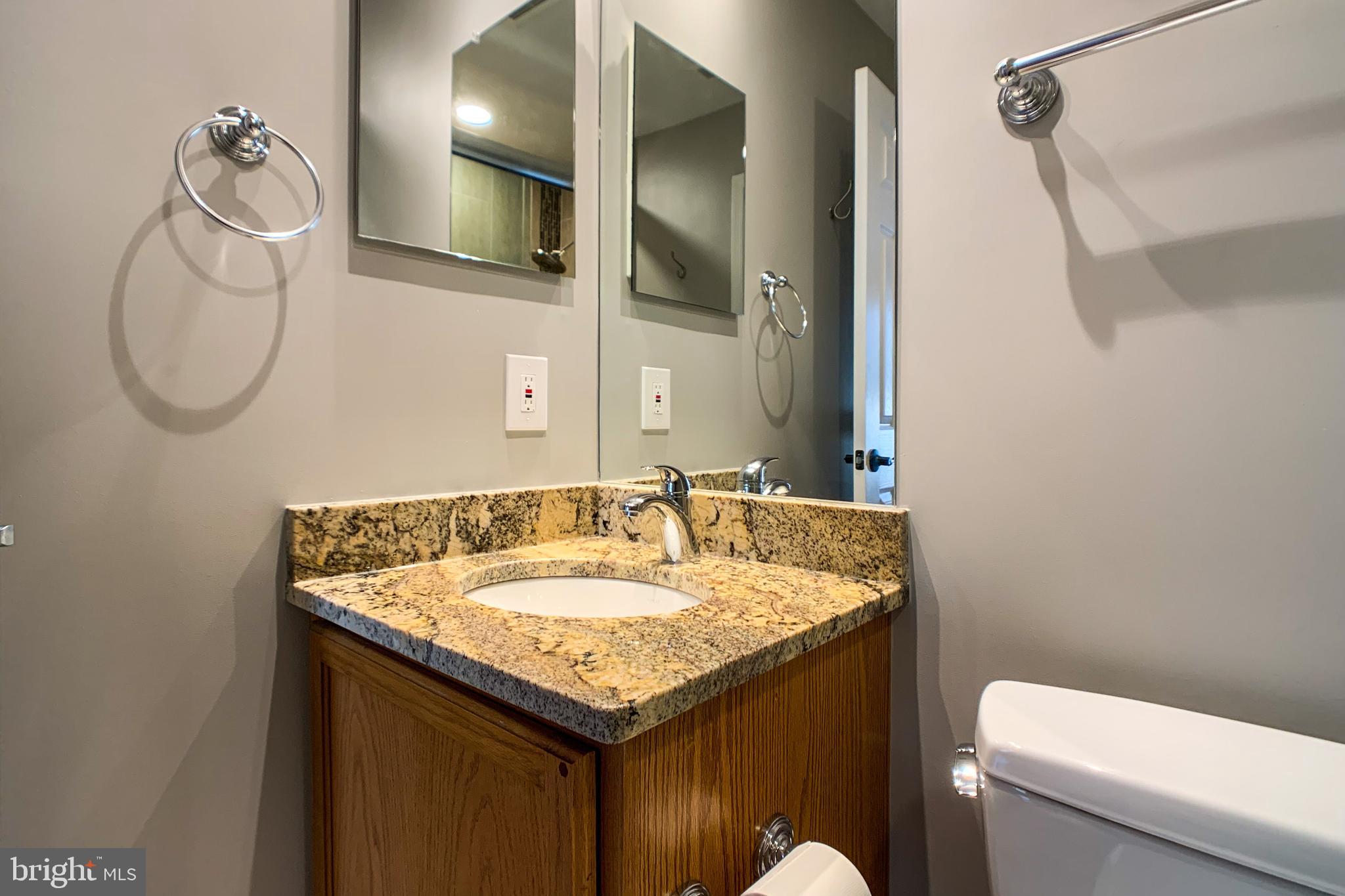 6988 Cromarty Drive Alexandria, VA 22315 - Photo 50 of 62 a bathroom with a granite countertop sink and a mirror