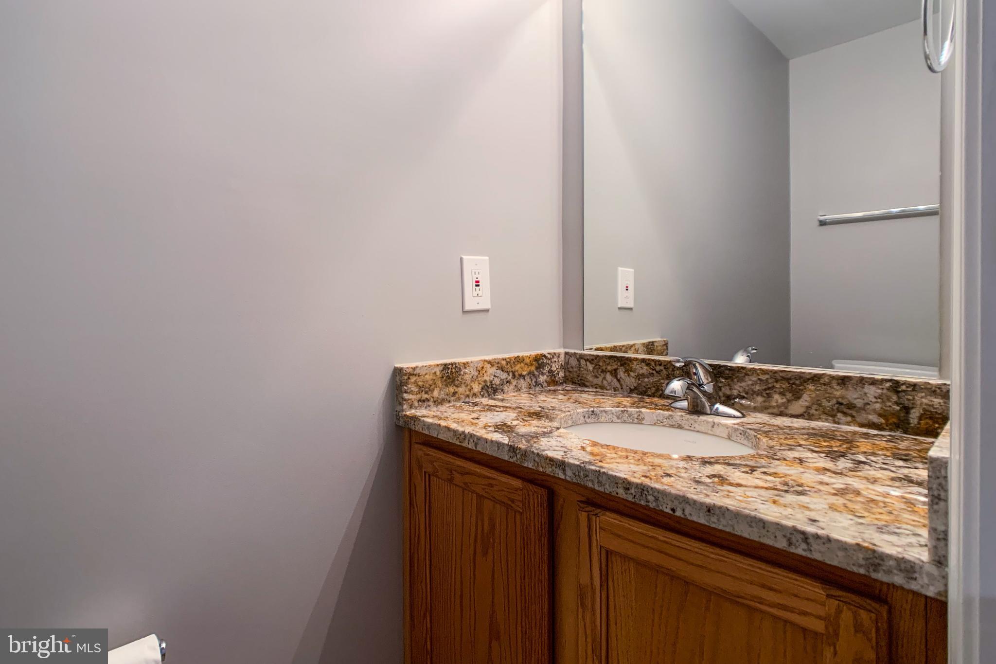 6988 Cromarty Drive Alexandria, VA 22315 - Photo 53 of 62 a bathroom with a granite countertop sink and a mirror