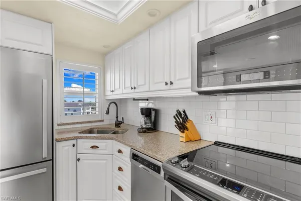 a kitchen with a sink appliances and cabinets