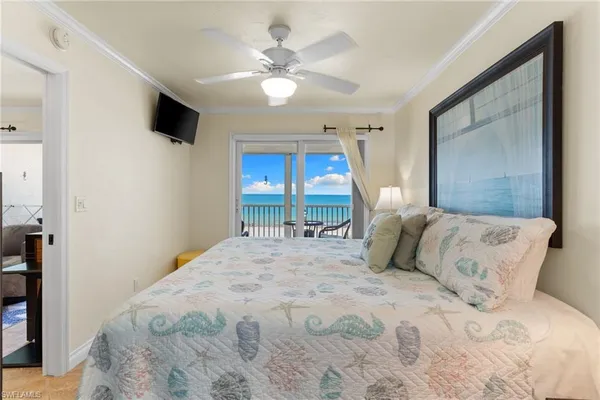 a bedroom with a large bed and a chandelier