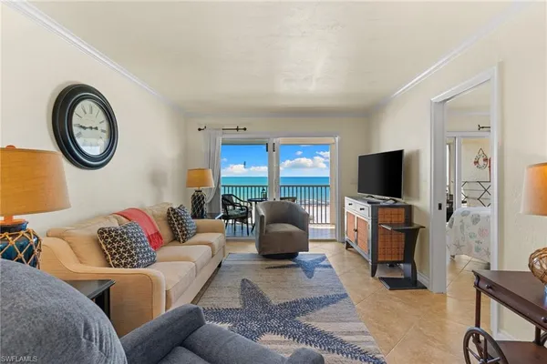 a living room with furniture a flat screen tv and a window