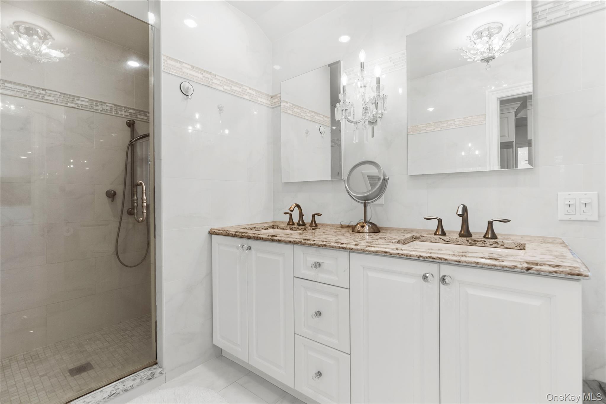 28 Annandale Road Commack, NY 11725 - Photo 16 of 29 Bathroom featuring double vanity, a shower stall, and a chandelier