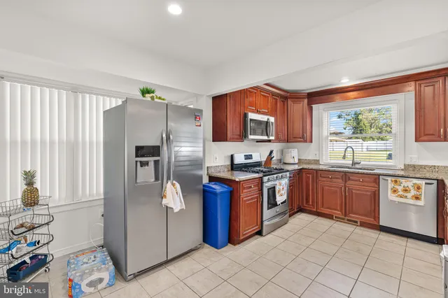 a kitchen with stainless steel appliances granite countertop a refrigerator and a stove top oven