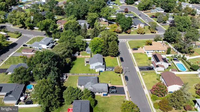 an aerial view of a residential houses with yard