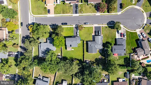 an aerial view of residential houses with outdoor space and trees all around